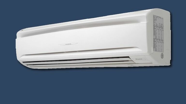 Kompakt veggmontert innedel for klimaanlegg med slankt design og frontdeksel i hvitt plast.